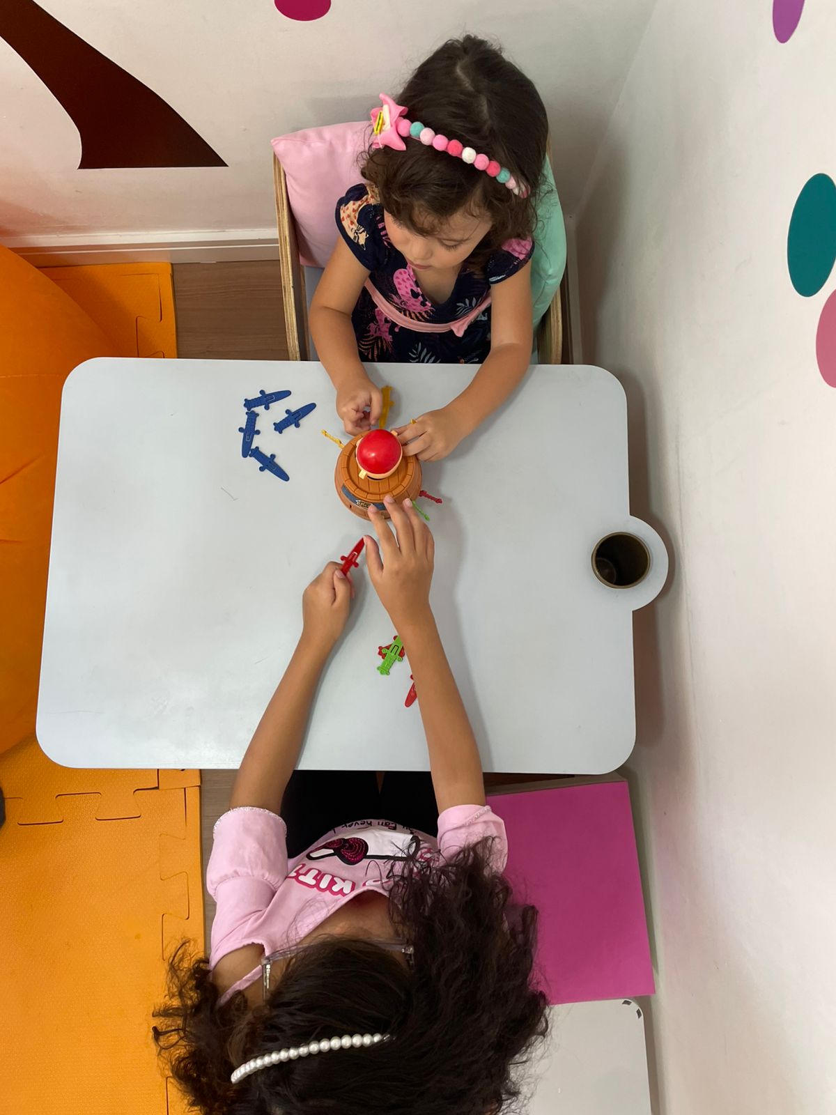 Terapia ocupacional infantil - profissional auxiliando criança em exercício de desenvolvimento motor e social